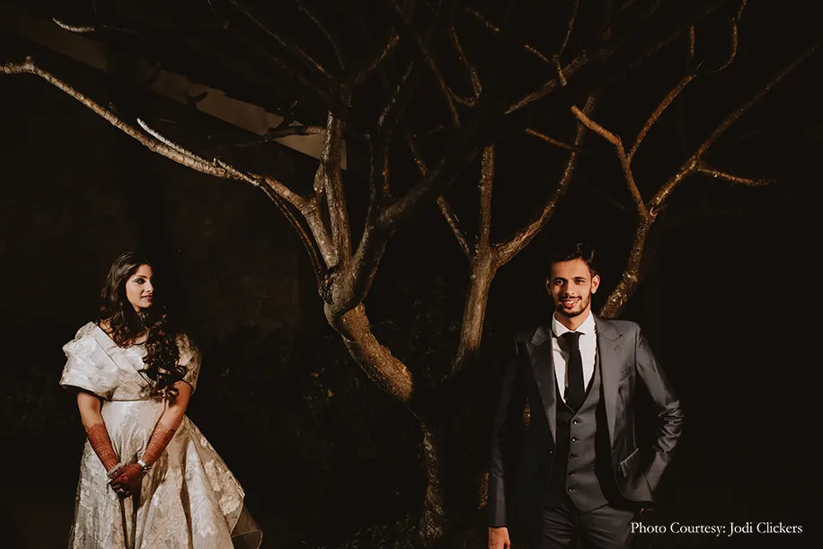 Bride wearing off-white gown by Gaurav Gupta and groom wearing three peice suit by Govinda Mehta